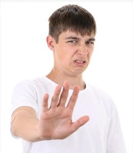 Young man holding up a hand to say stop with a disgusted grimace