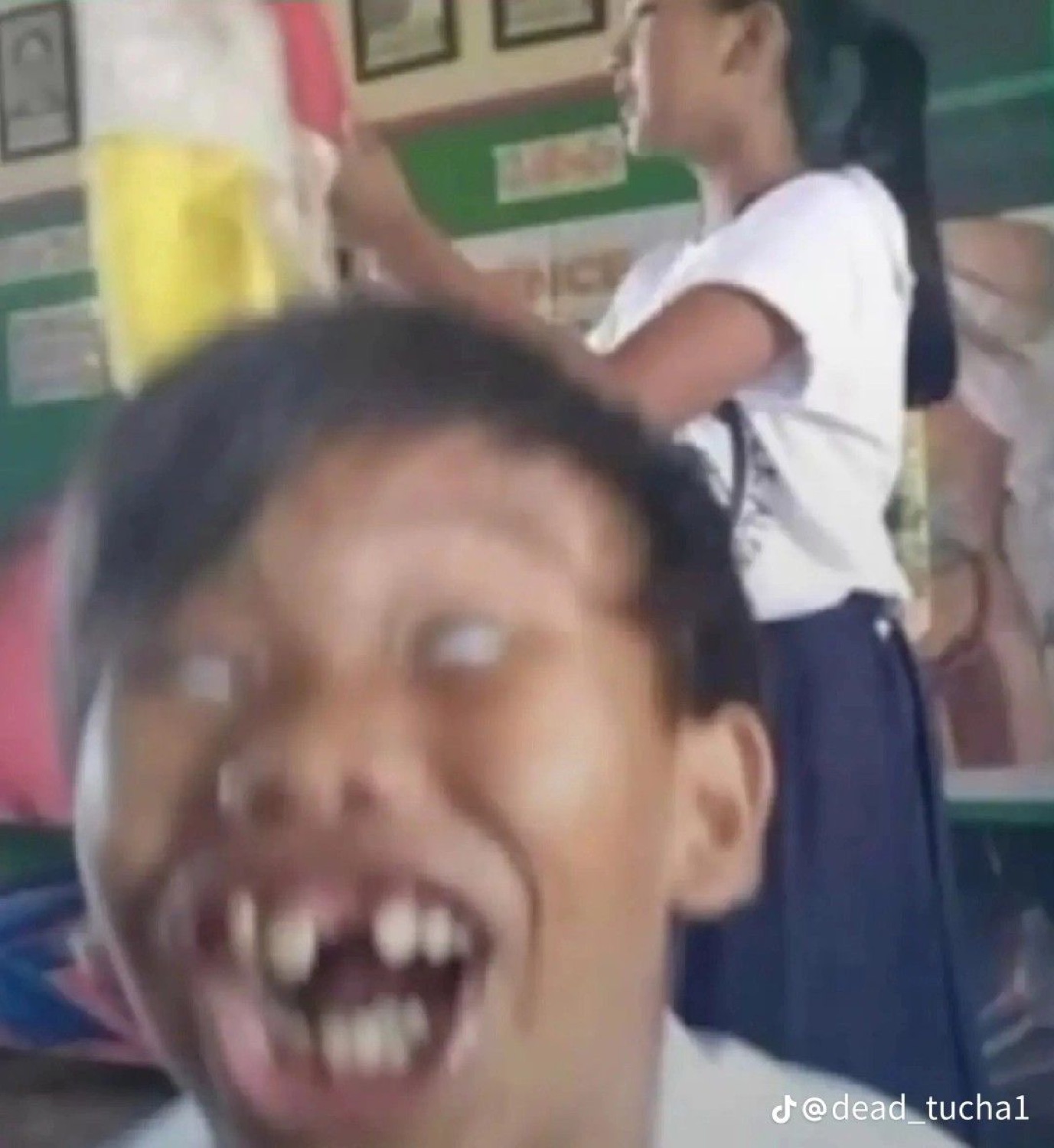 Blurry close-up of a kid making a wild goofy face with eyes rolled back