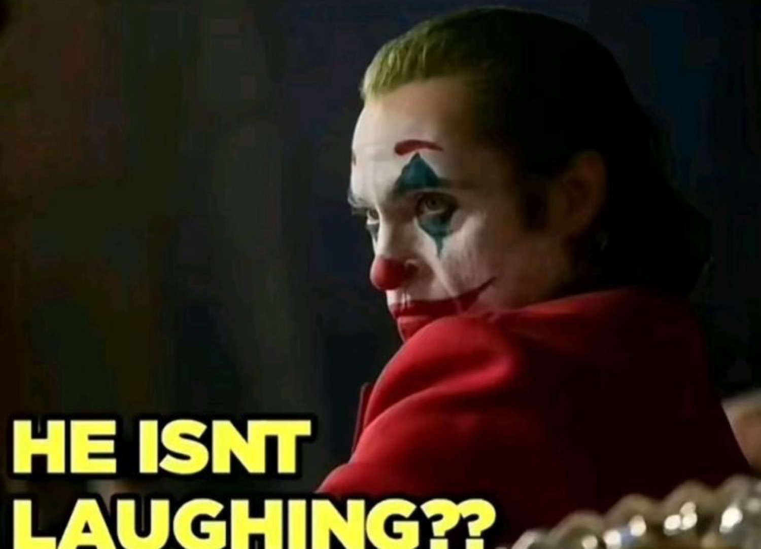 Joker looking back with zero amusement while the caption asks if he's laughing