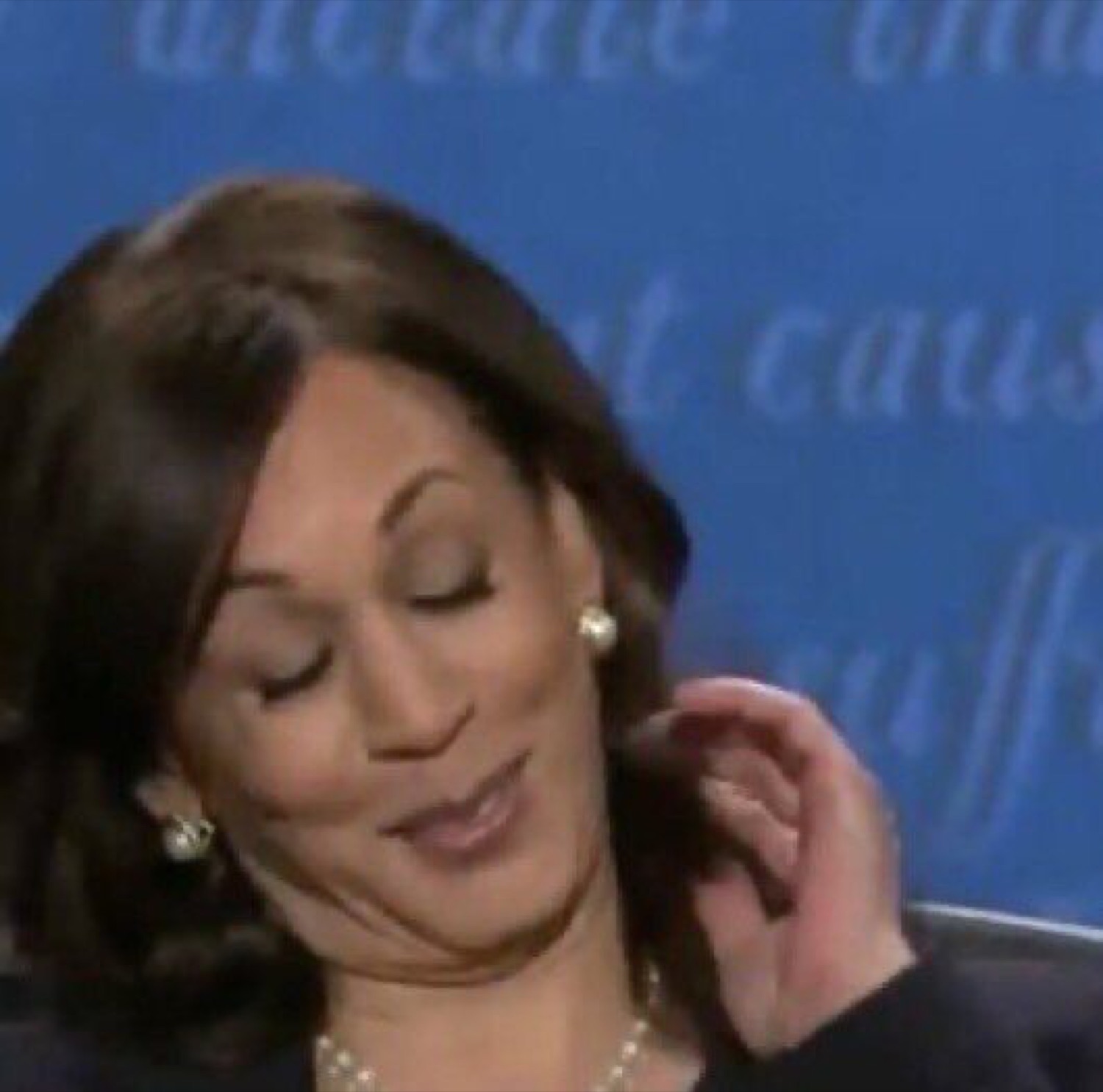 Kamala Harris with eyes closed and a smug little smile mid-debate