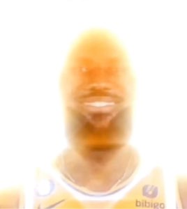 Basketball player's face blown out to a blinding orange glow while grinning
