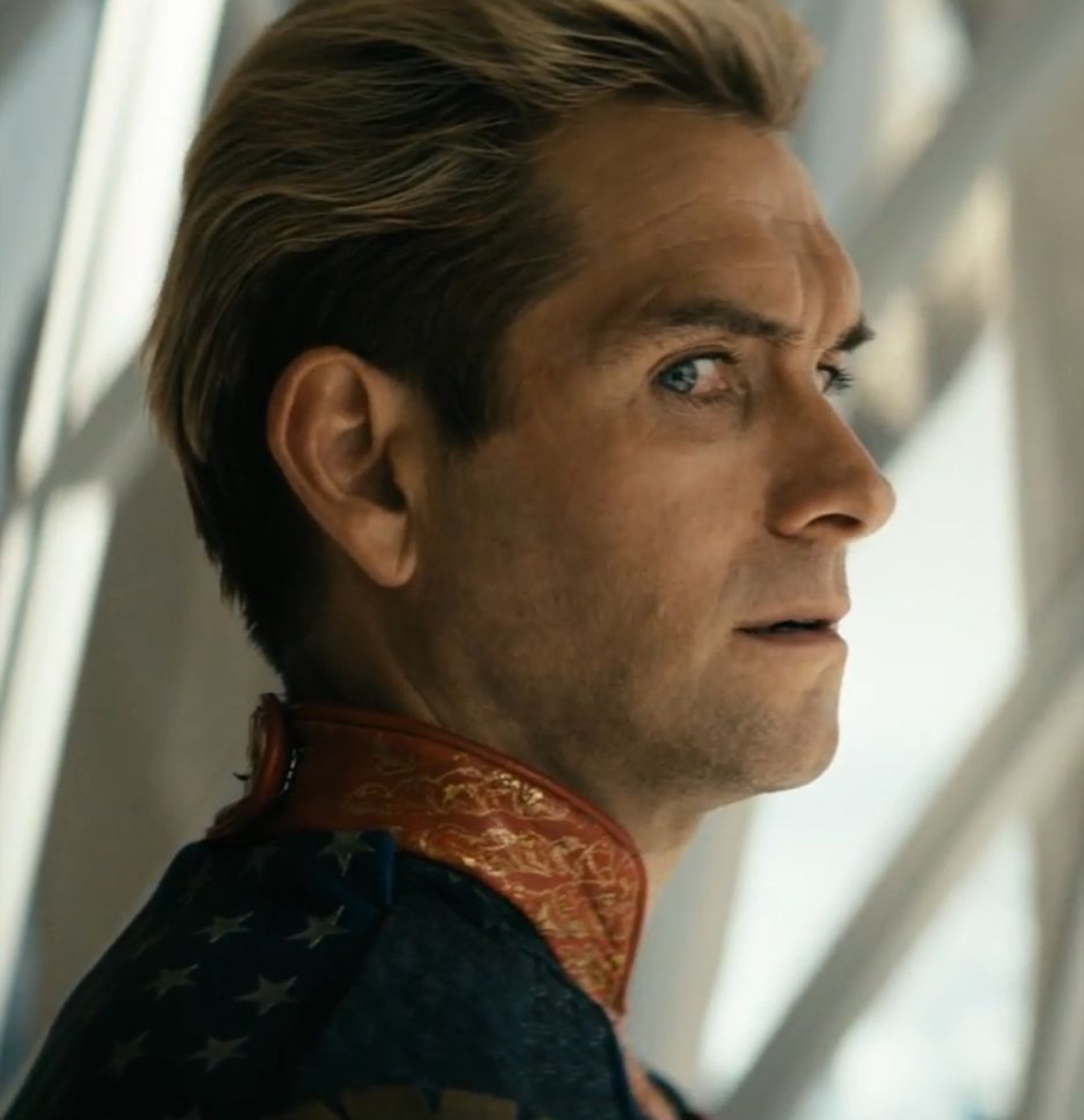 Blond man in a patriotic collar giving a slow, suspicious side-eye toward the window