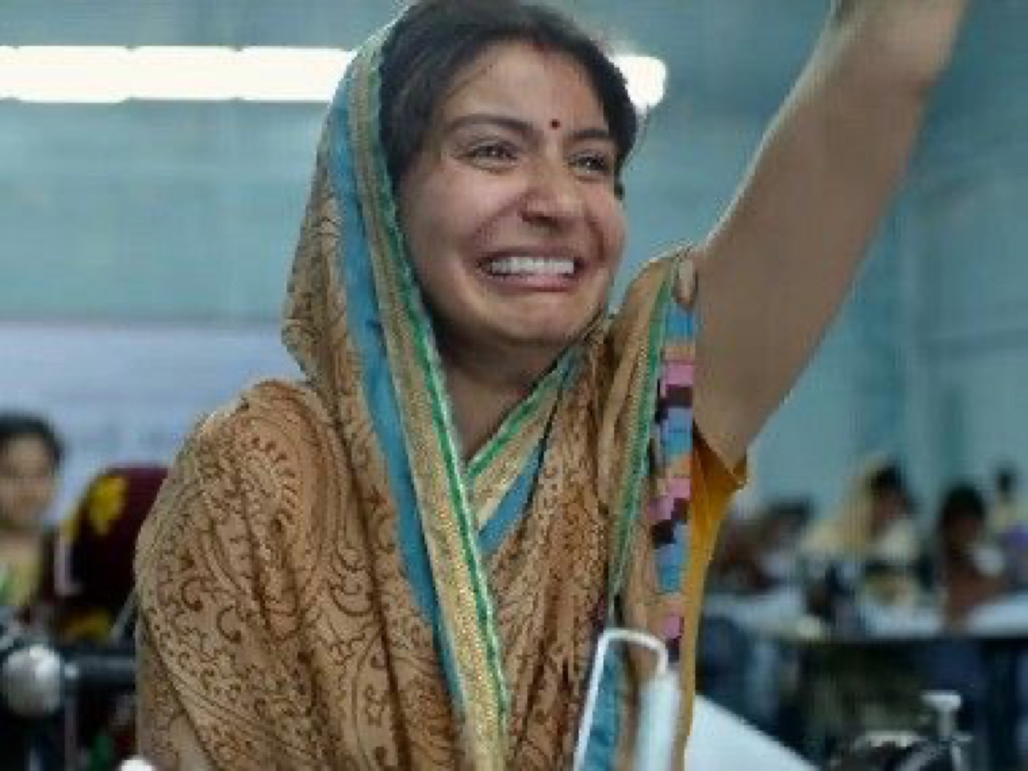 Anushka Sharma in a dupatta waving with a huge happy grin