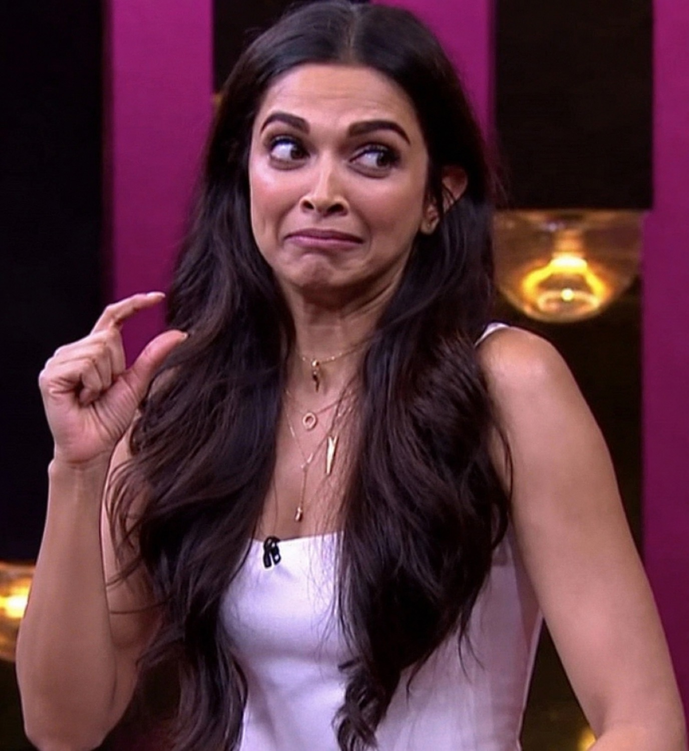 Deepika Padukone pinching her fingers together with an awkward grimace