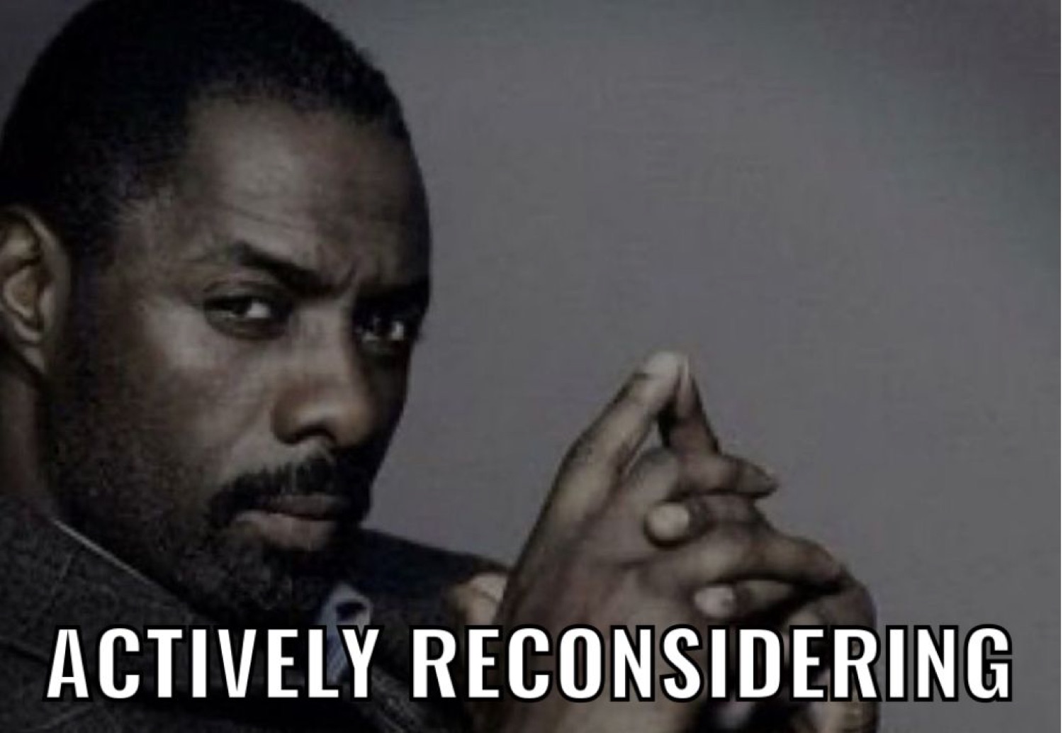 Man with steepled fingers giving a hard side-look, captioned 'ACTIVELY RECONSIDERING'