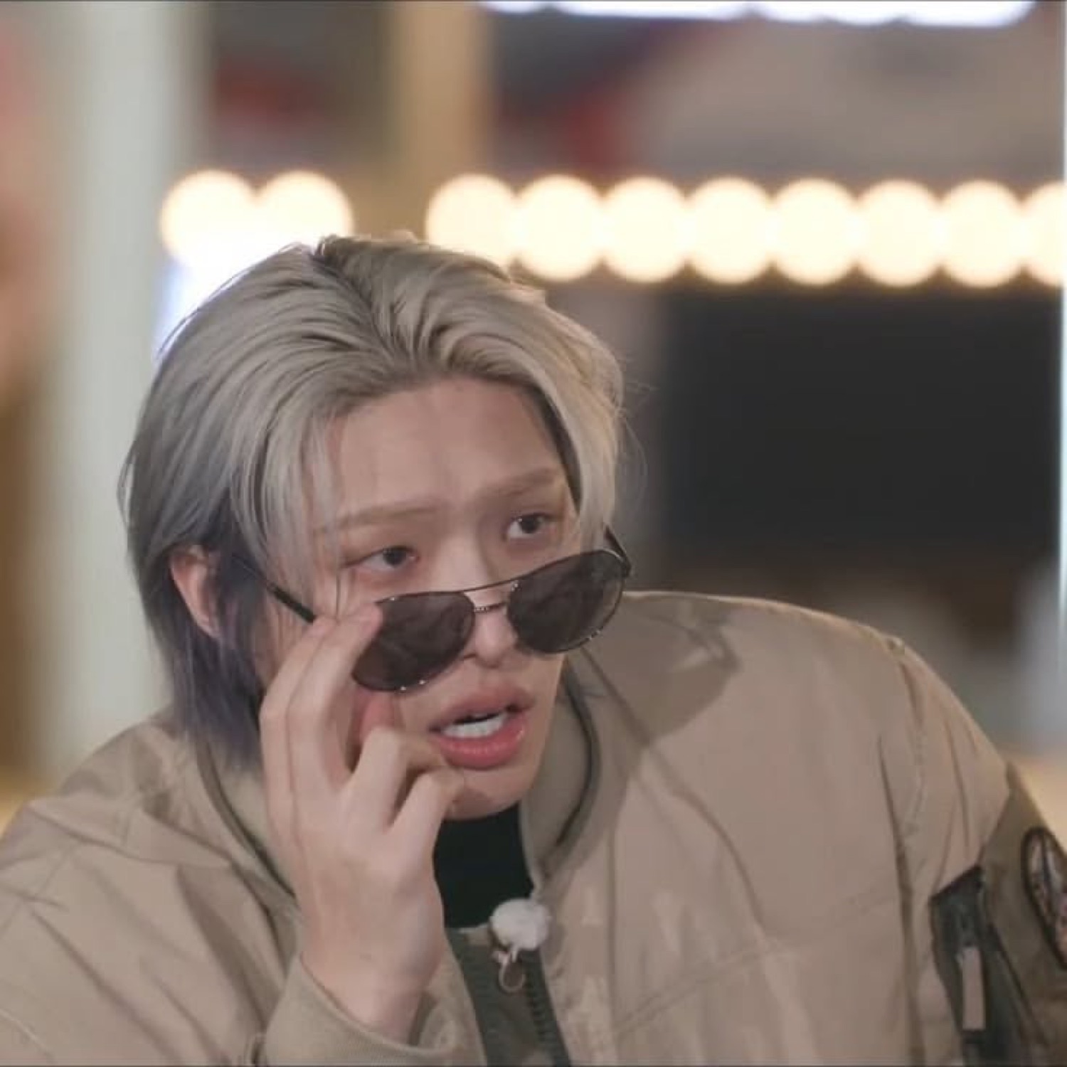 Silver-haired guy lowering his sunglasses mid-sentence, fully scandalized