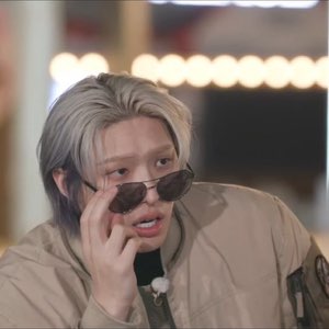 Silver-haired guy lowering his sunglasses mid-sentence, fully scandalized