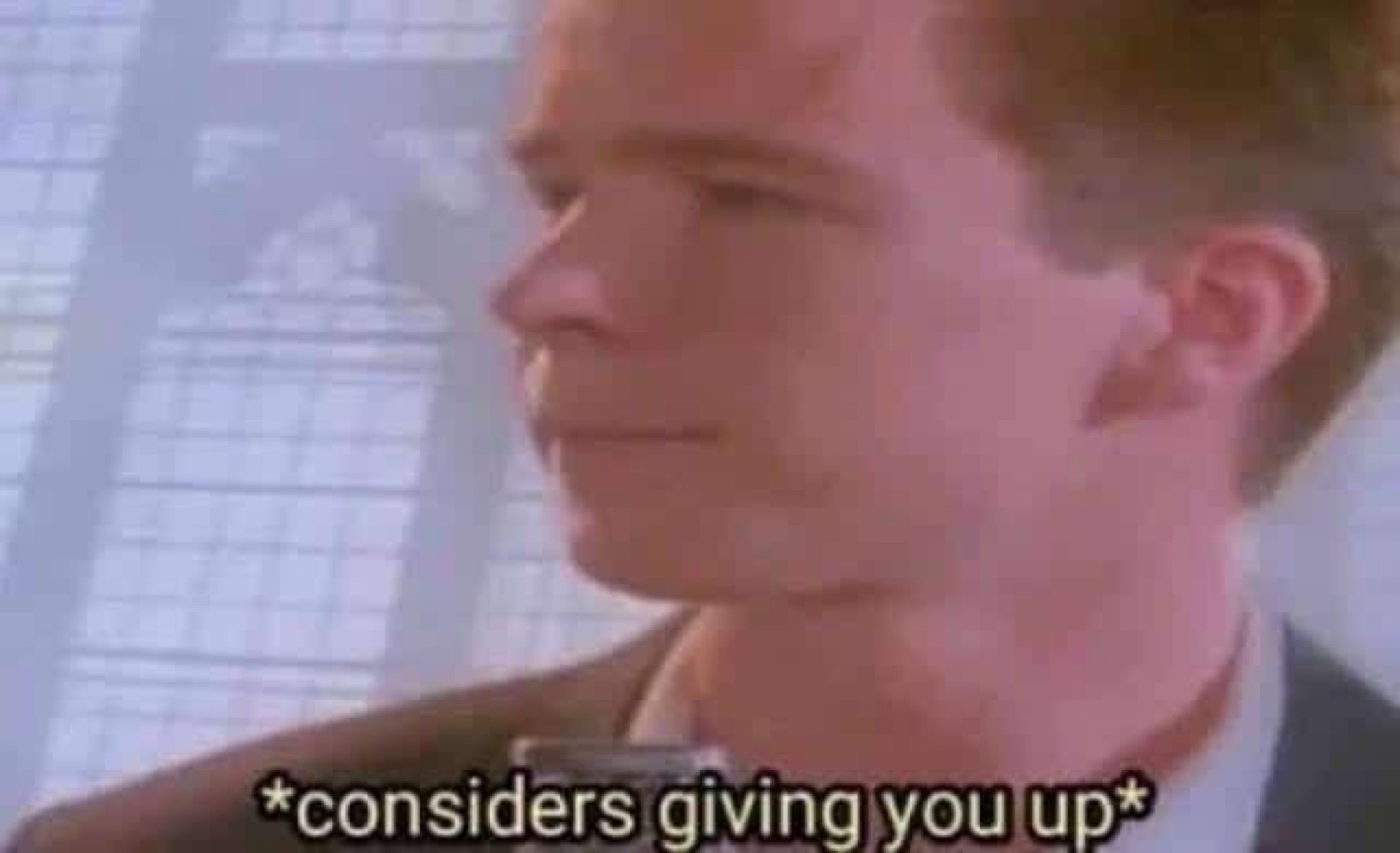 Man in profile with a slight smirk, captioned '*considers giving you up*'