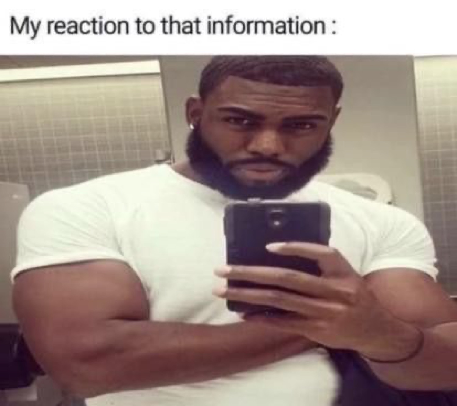 Buff guy taking a bathroom mirror selfie with a flat unimpressed stare, 'My reaction to that information :'