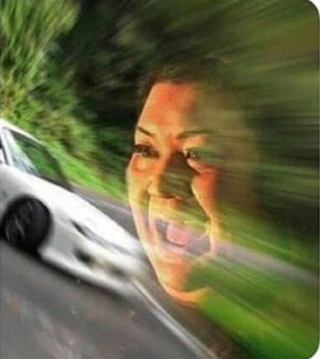 Woman with wind blasting her face as a car speeds past