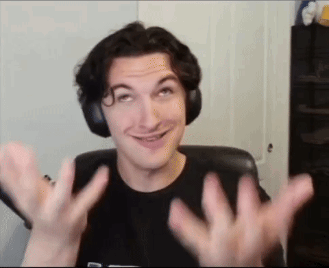 Young man in headphones grinning and wiggling his hands up and down doing the six seven gesture