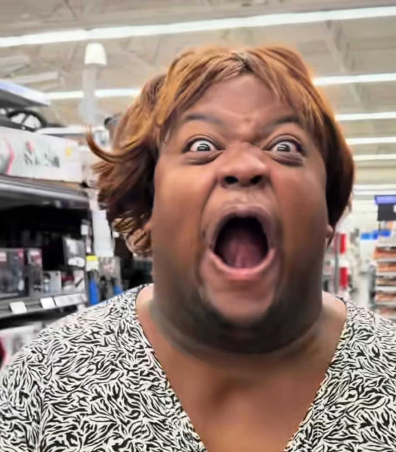 Person in a store screaming with eyes bulging and mouth wide open in shock
