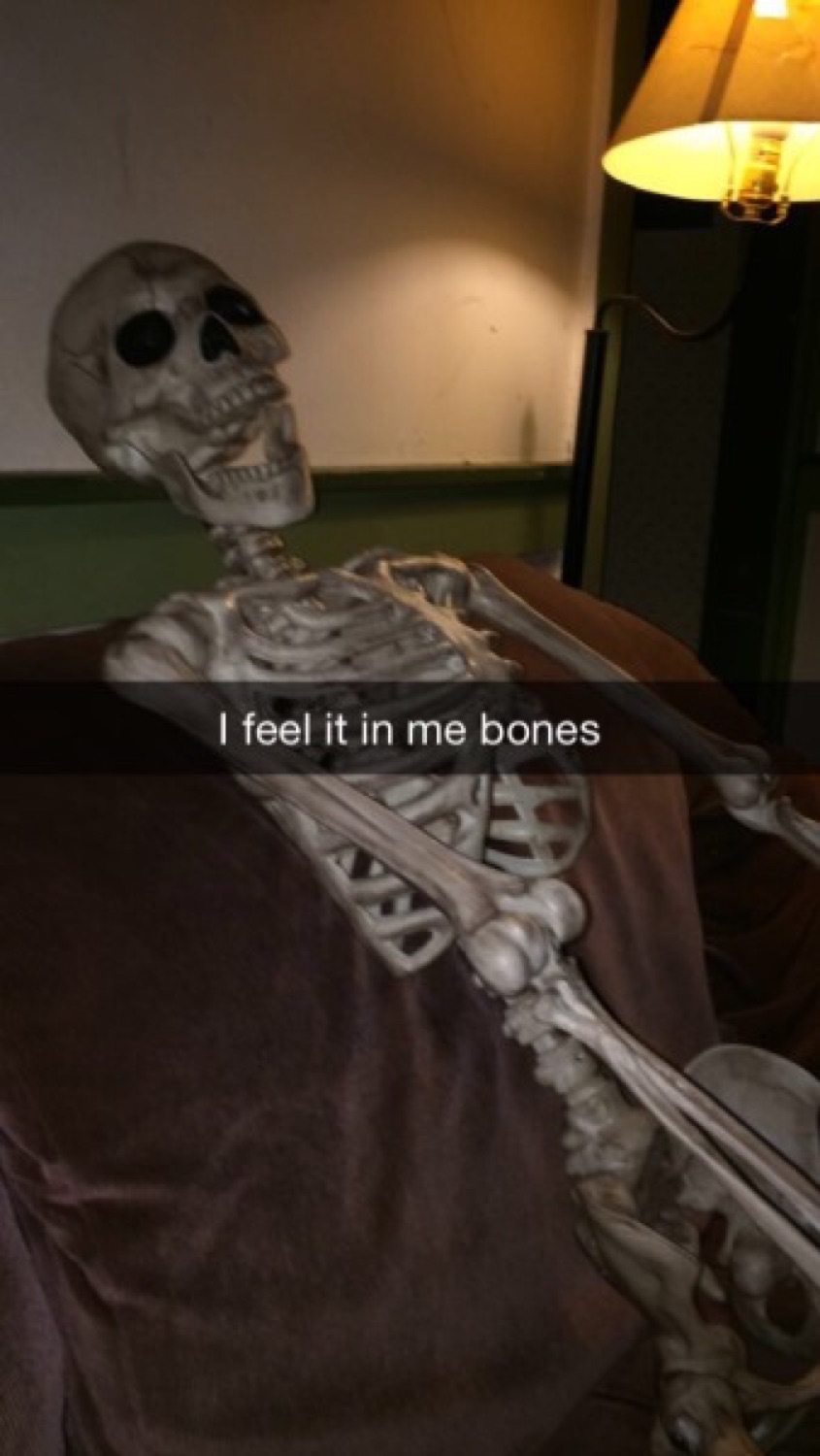 Skeleton slumped in a chair on a Snapchat captioned 'I feel it in me bones'