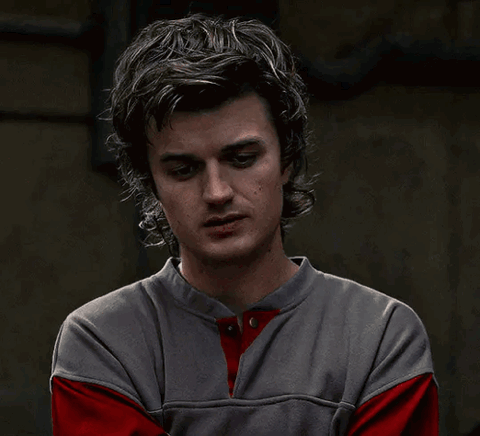 Steve Harrington from Stranger Things covering his face with his hands in frustration