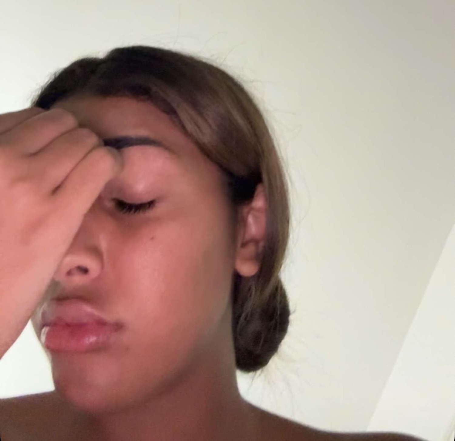 Young woman pressing her hand over her eyes in total exasperation