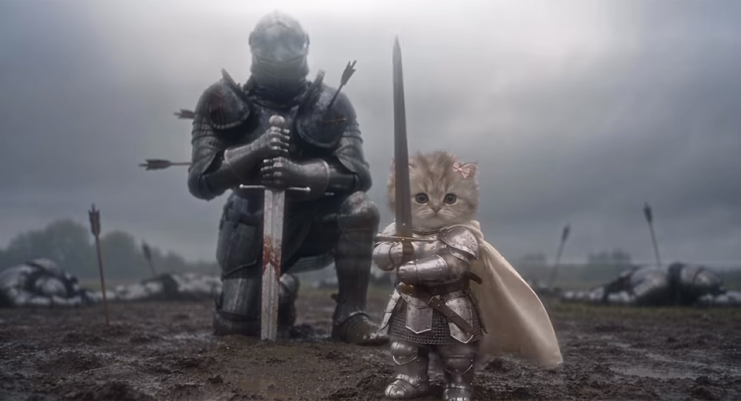 Tiny armored kitten with a sword standing beside a kneeling full-size knight on a battlefield