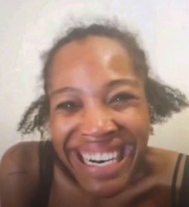 Woman on a video call cracking up with a huge open-mouthed laugh