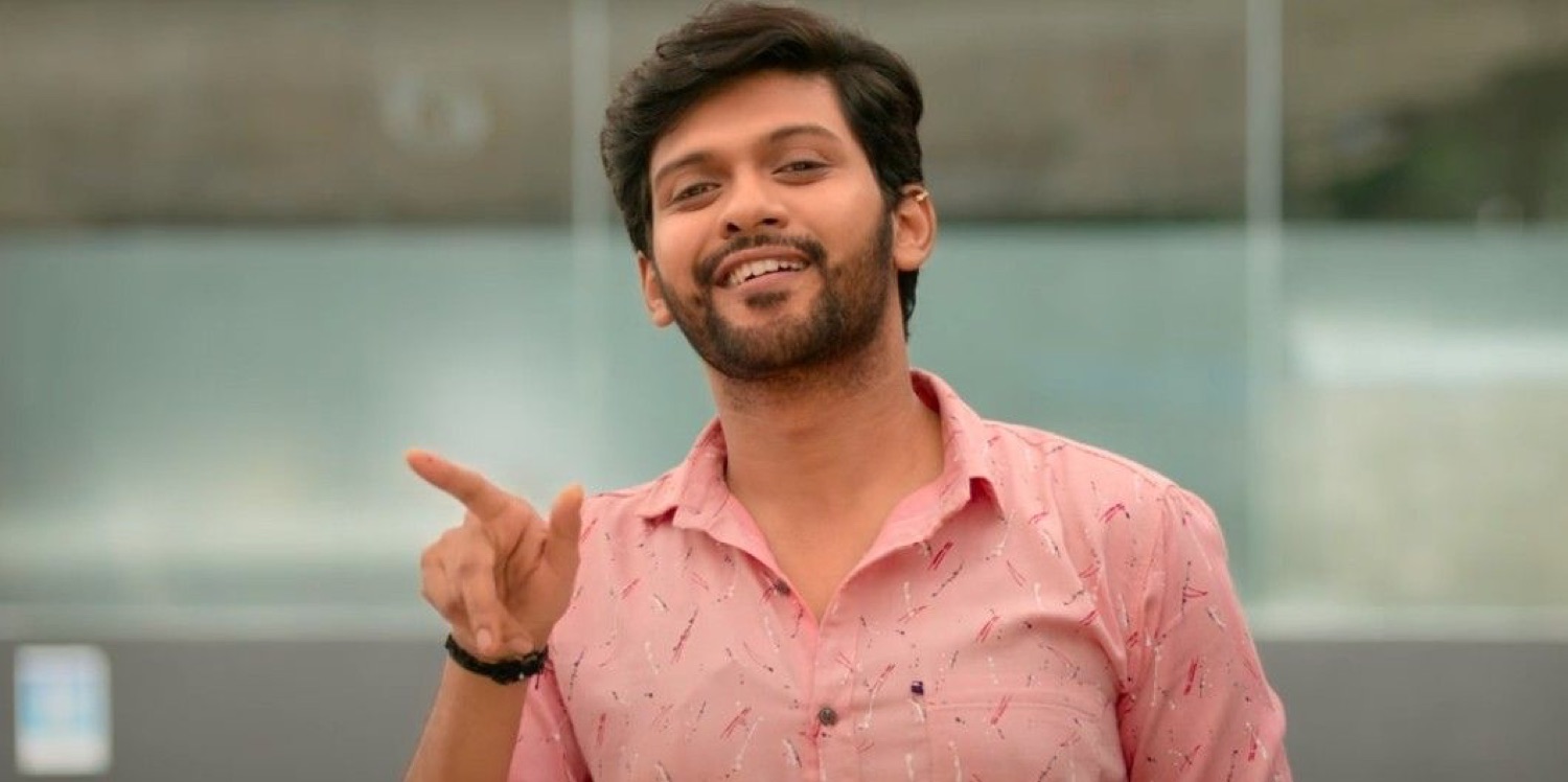 Young man grinning and pointing at the camera