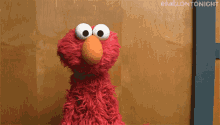 Elmo throwing up his arms in a shrug