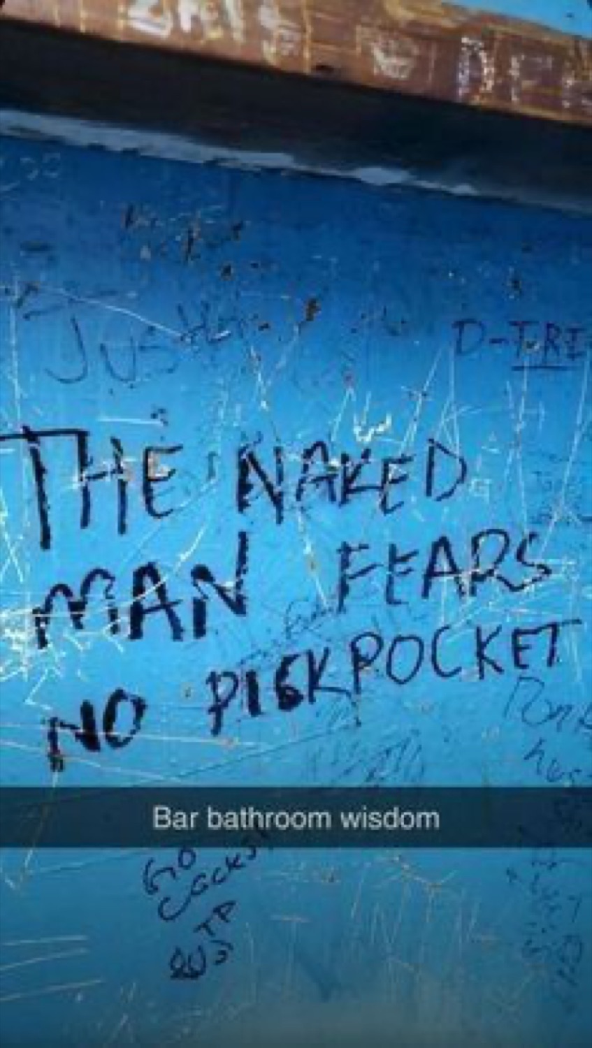 Bar bathroom graffiti reading 'The naked man fears no pickpocket', captioned 'Bar bathroom wisdom'