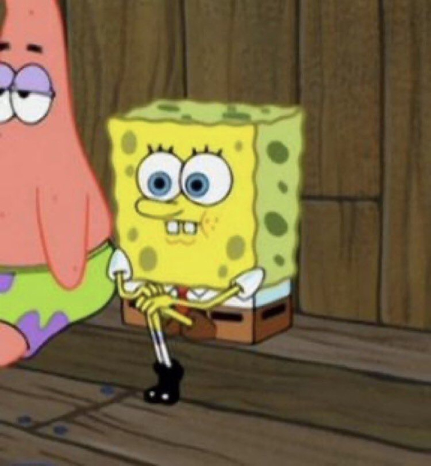SpongeBob SquarePants sitting awkwardly with his fingers twisted together and a tense grin