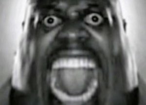 Grainy black-and-white close-up of a man screaming with wide bulging eyes