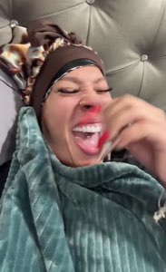 Woman in a bonnet lying back and laughing hard while pointing at the camera
