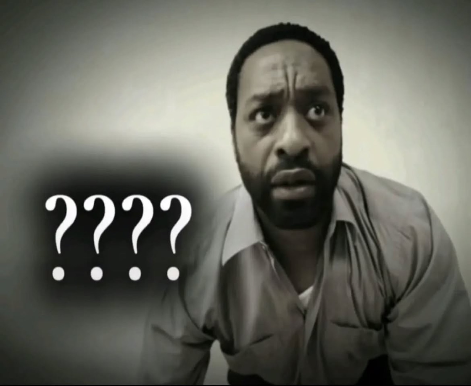 Man leaning in with a skeptical, furrowed look next to four big question marks