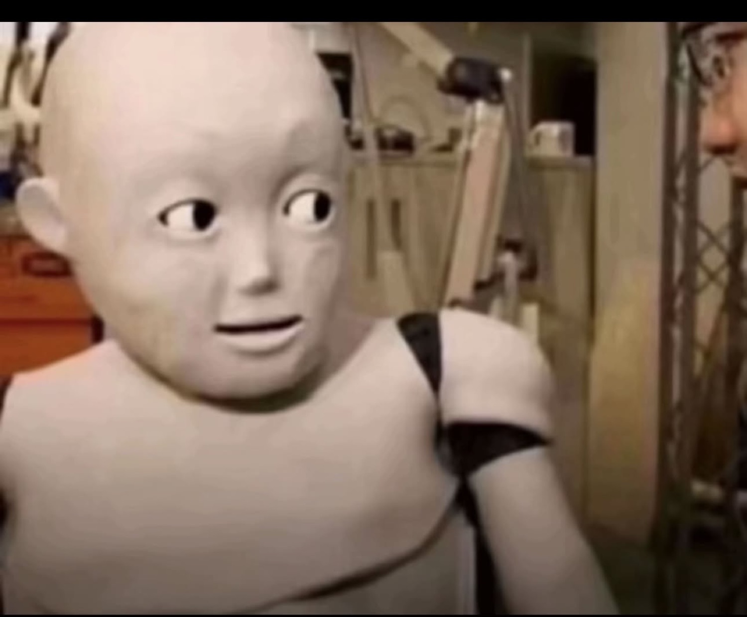 Creepy CGI baby robot with wide side-glancing eyes and an unsettled stare