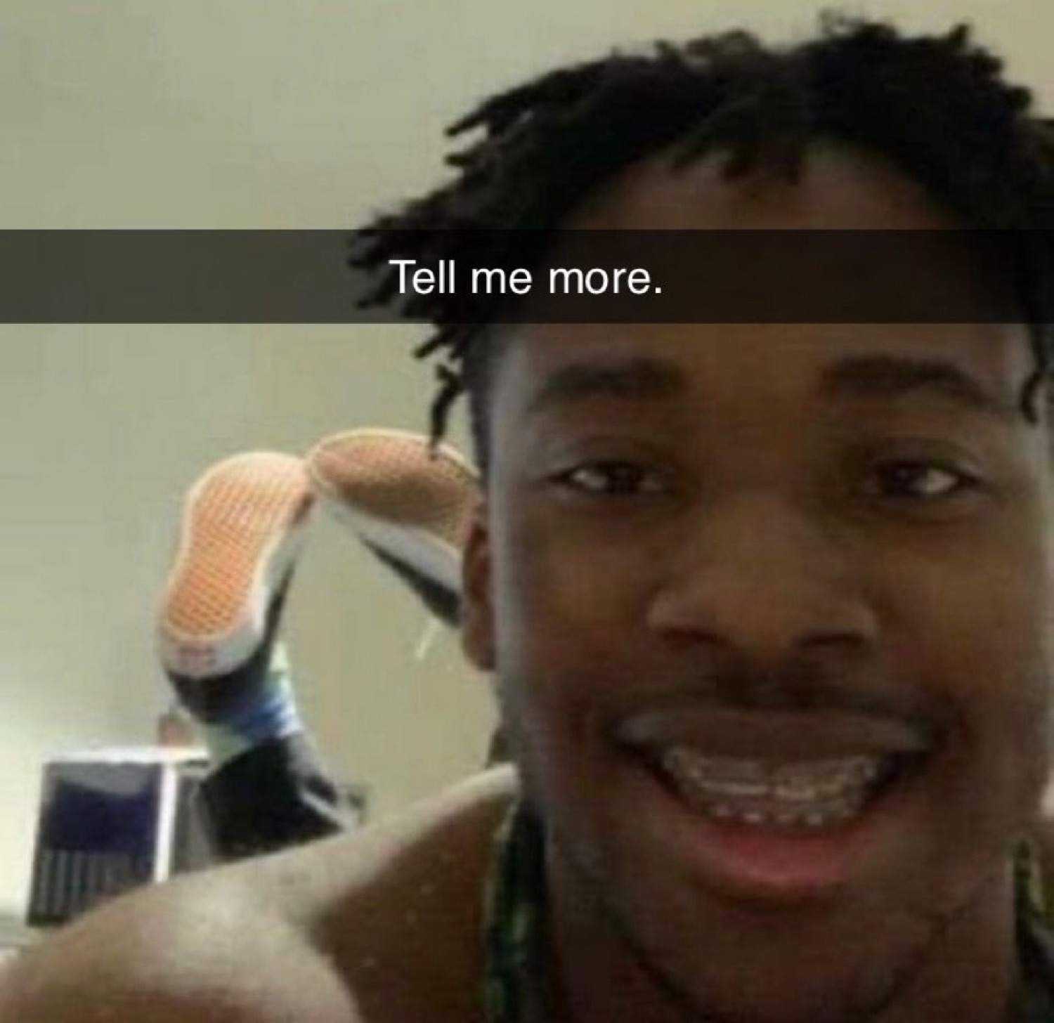 Guy grinning wide with braces and a Snapchat caption that says 'Tell me more.'