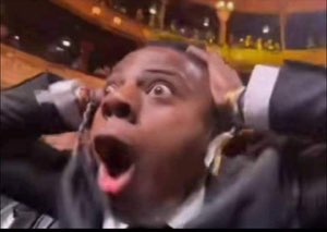 Man clutching his head with both hands and screaming in absolute shock at an awards show