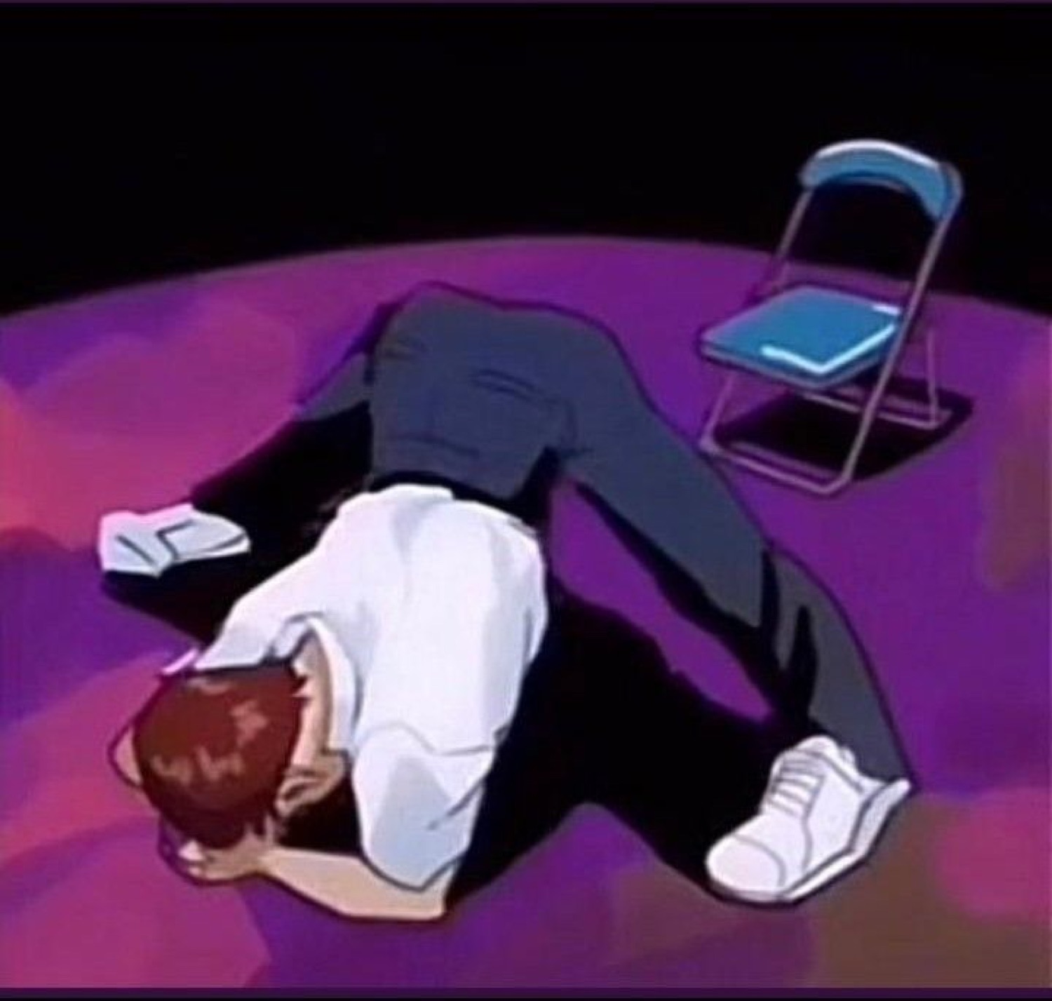 Man bowing face-down on a stage next to a folding chair