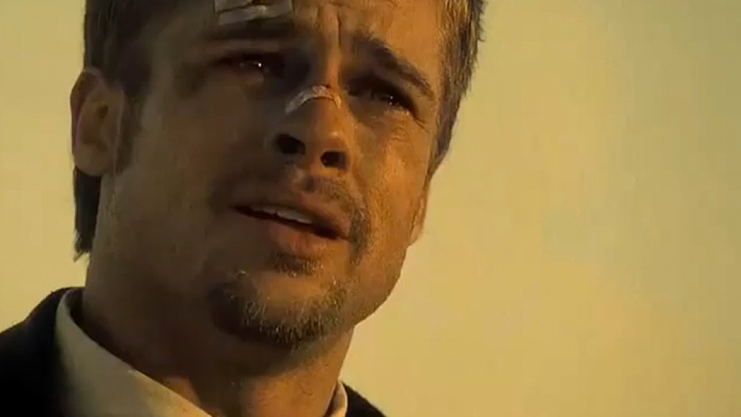 Man with tears streaming down his face looking up with a broken, emotional expression