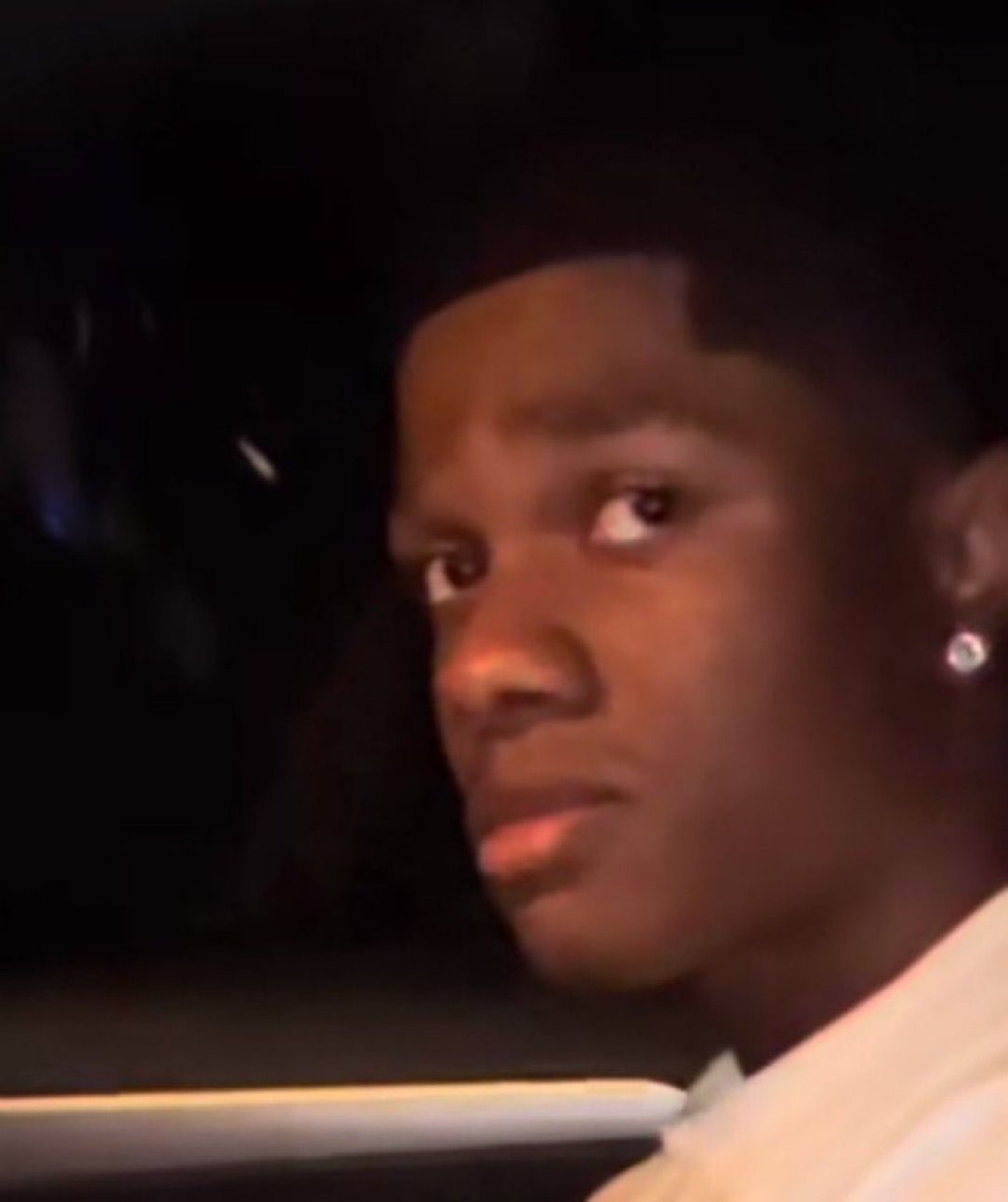Young man in a car at night turning to shoot a skeptical side-eye