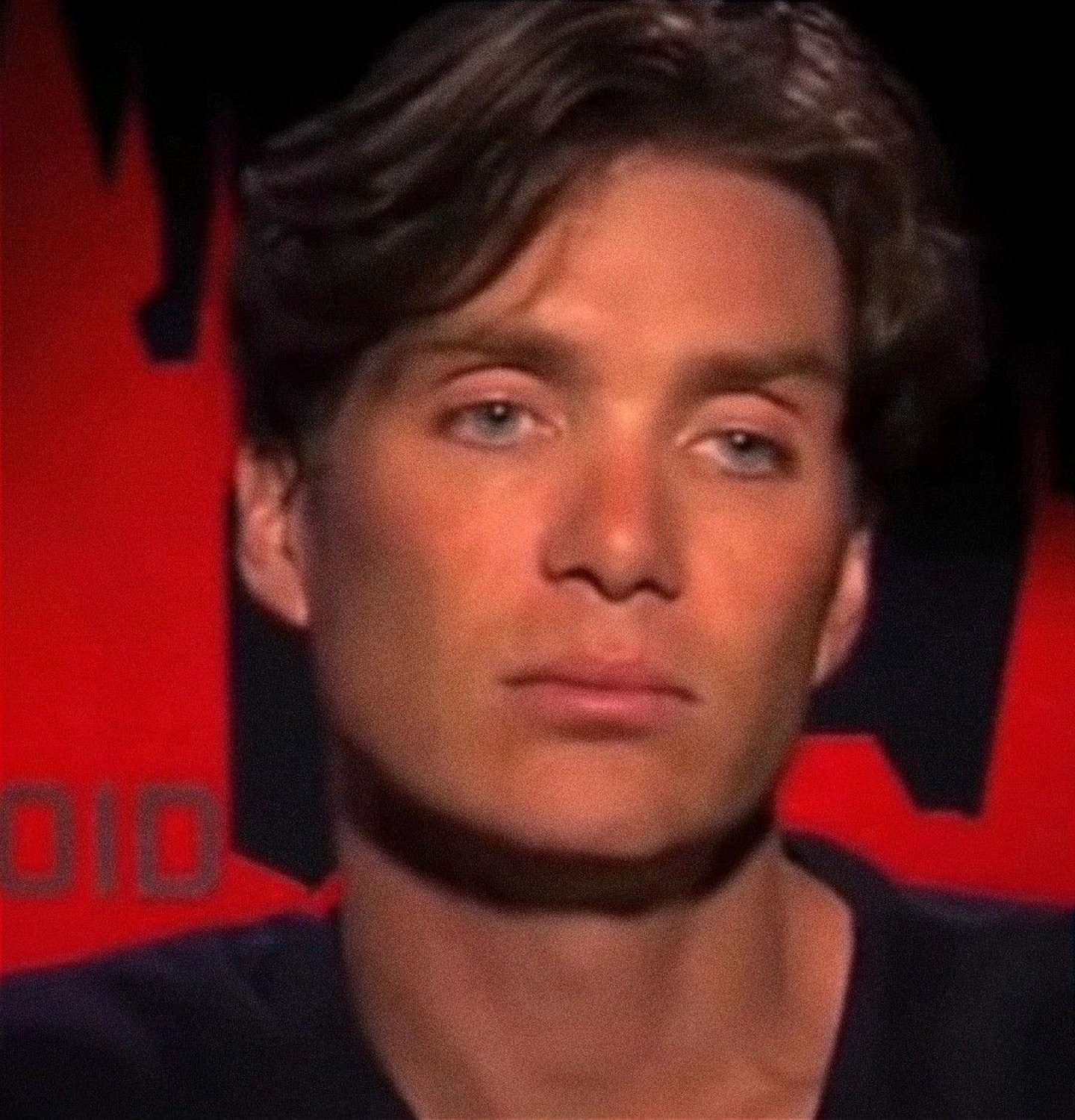 Cillian Murphy staring directly into the camera with piercing blue eyes and zero emotion