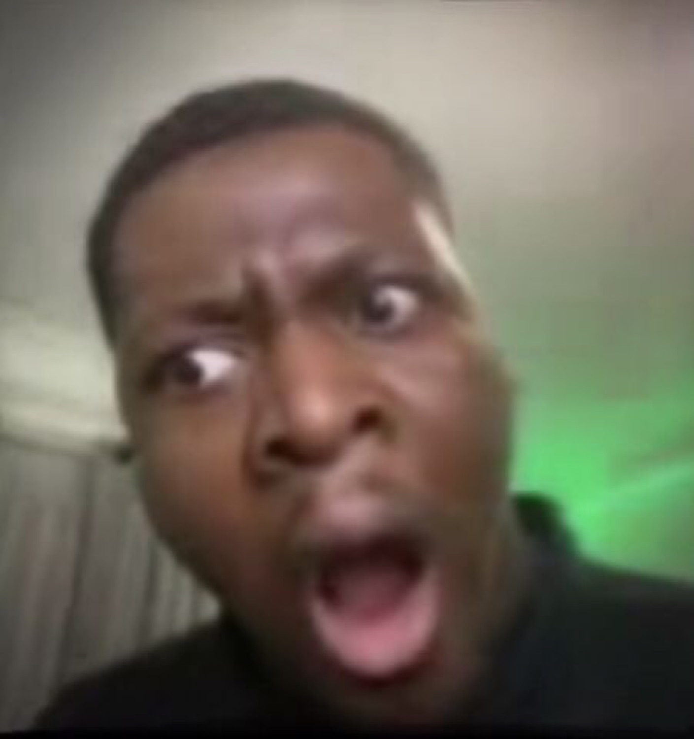 Man screaming with wide eyes and open mouth, caught completely off guard on camera