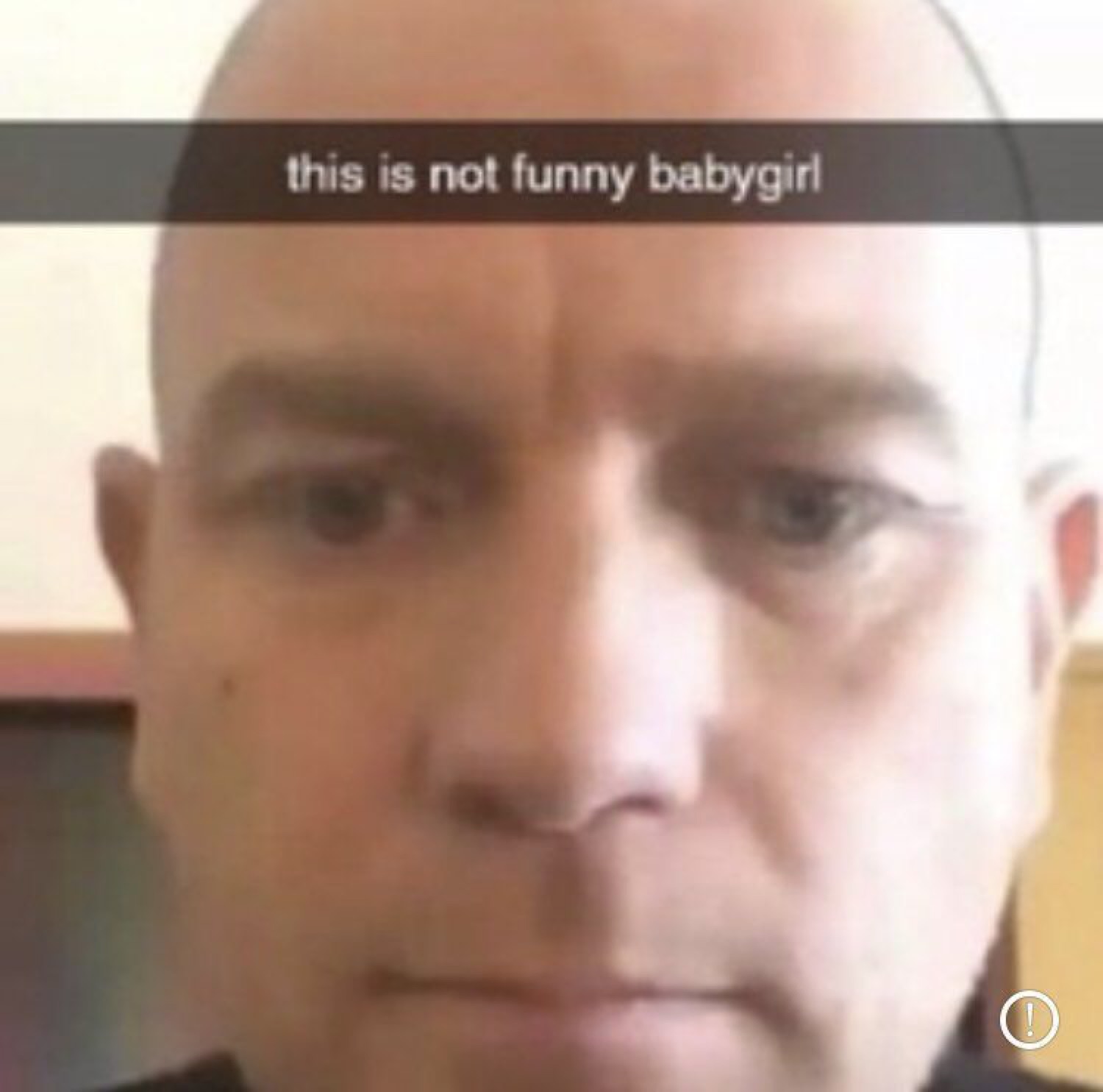 Stone-faced bald man in a selfie captioned 'this is not funny babygirl'