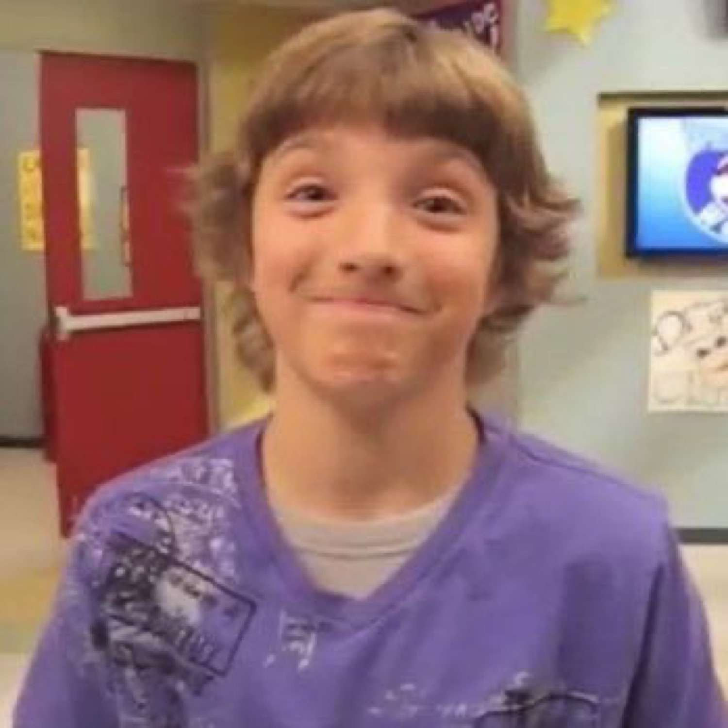 Kid with shaggy hair pressing his lips together in an awkward, guilty little smile