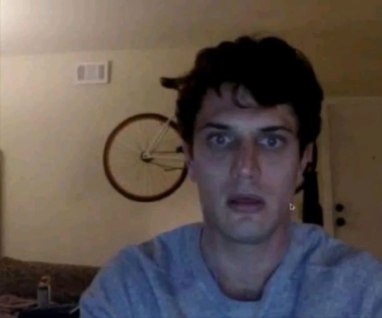 Guy on webcam staring into the camera with a stunned, hollow expression