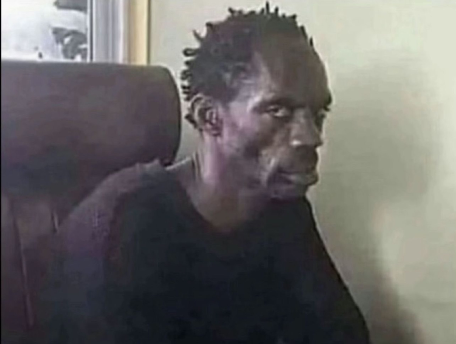 Man slumped in a chair throwing a wary, sideways glance