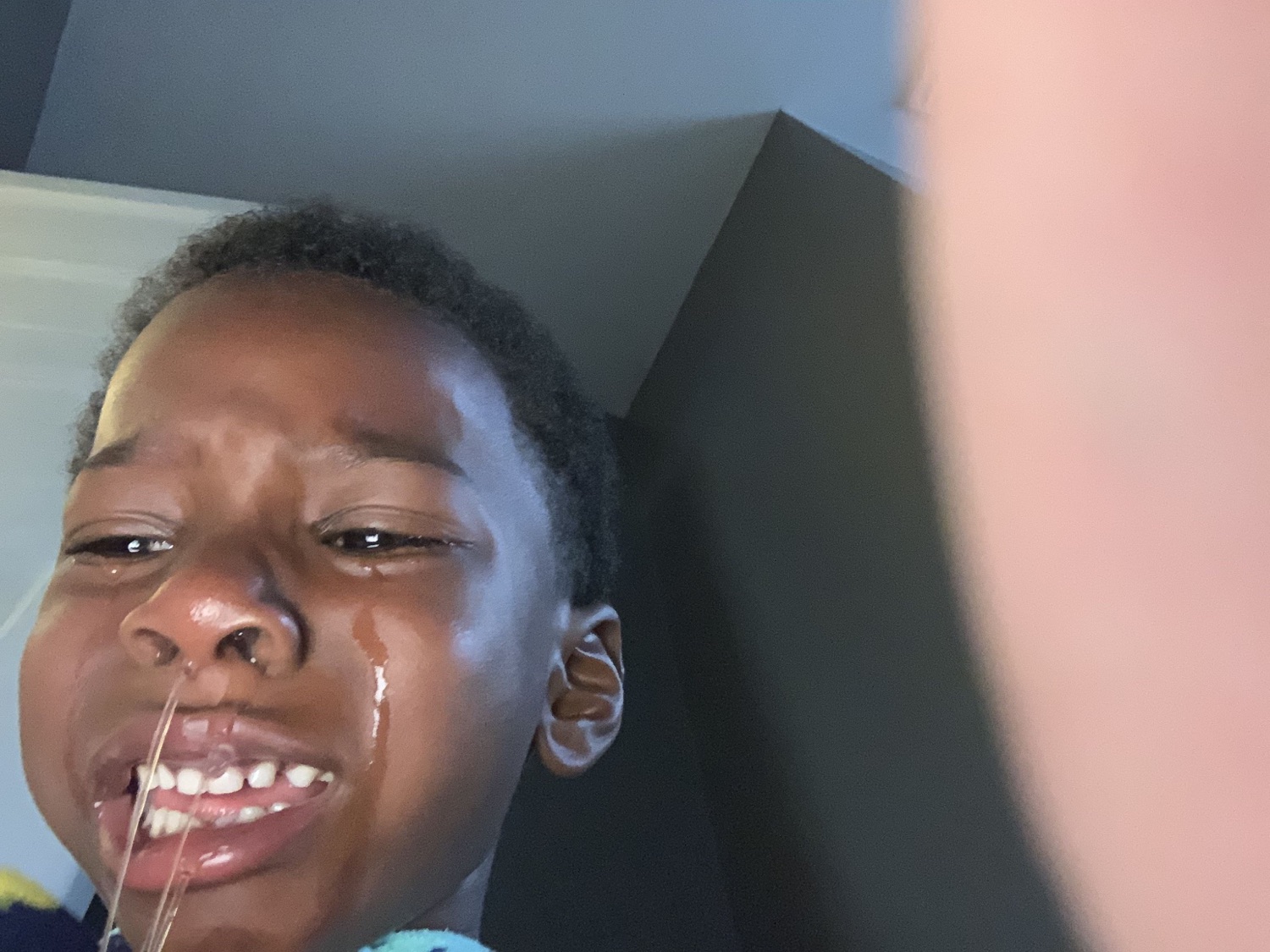 Young boy crying with tears and drool running down his face