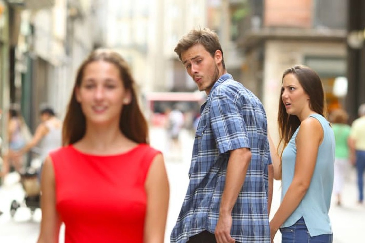 Classic Distracted Boyfriend meme - guy craning his neck to check out a woman in red while his girlfriend glares
