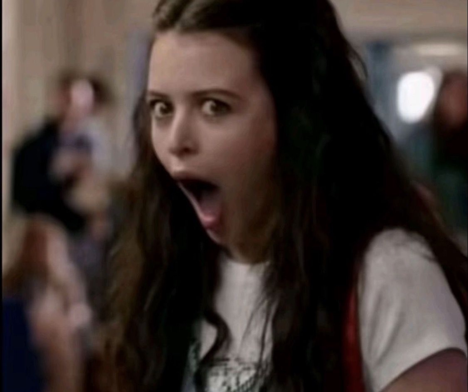 Girl in a hallway with jaw dropped in wide-eyed shock