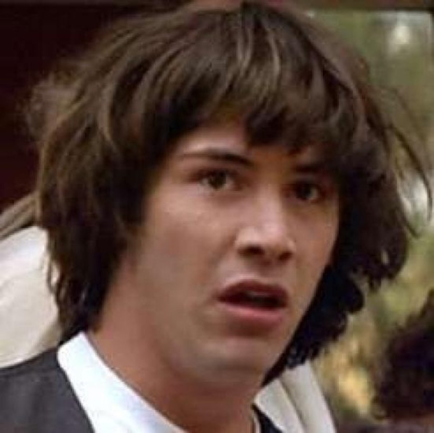Young man with long brown hair staring open-mouthed in complete disbelief