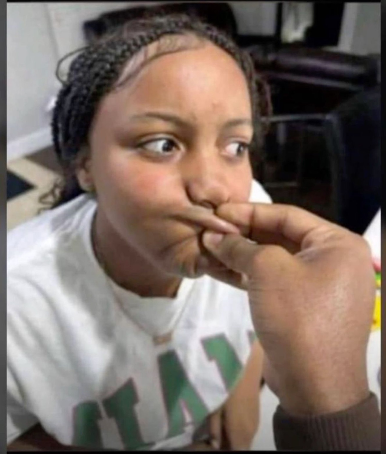 Girl side-eyeing while someone squishes her cheek with their fingers