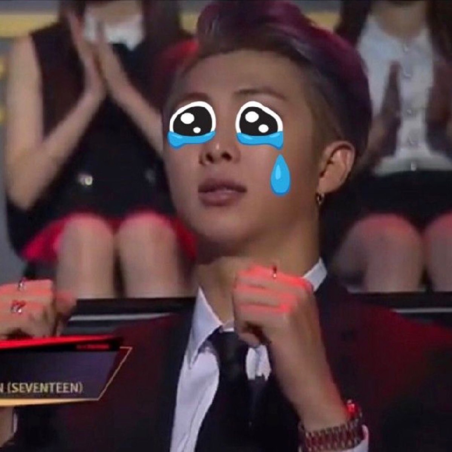 SEVENTEEN member at an awards show with animated crying-face emoji overlaid, fists clenched