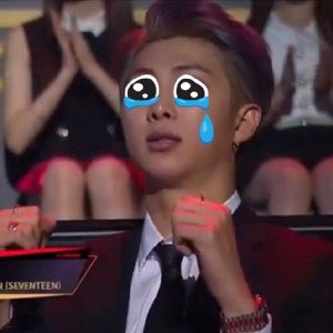 SEVENTEEN member at an awards show with animated crying-face emoji overlaid, fists clenched