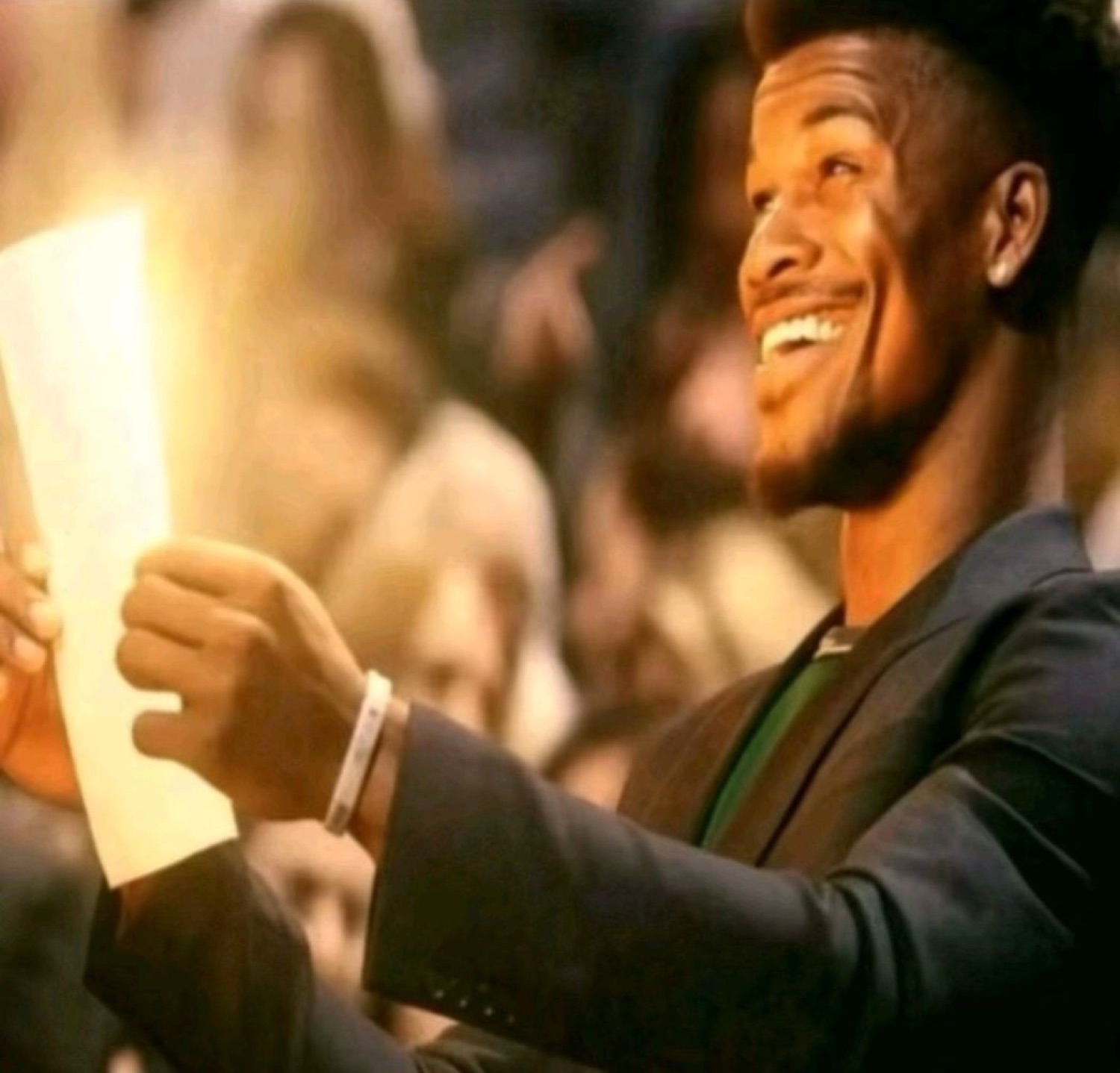 Jimmy Butler grinning wide as he reads a sheet of paper courtside