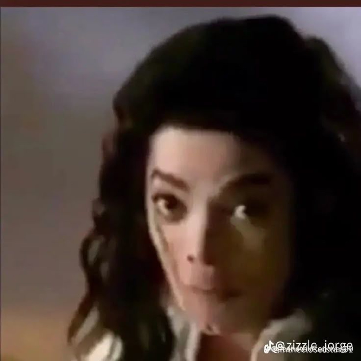 Michael Jackson turning with wide, startled eyes in a grainy video still