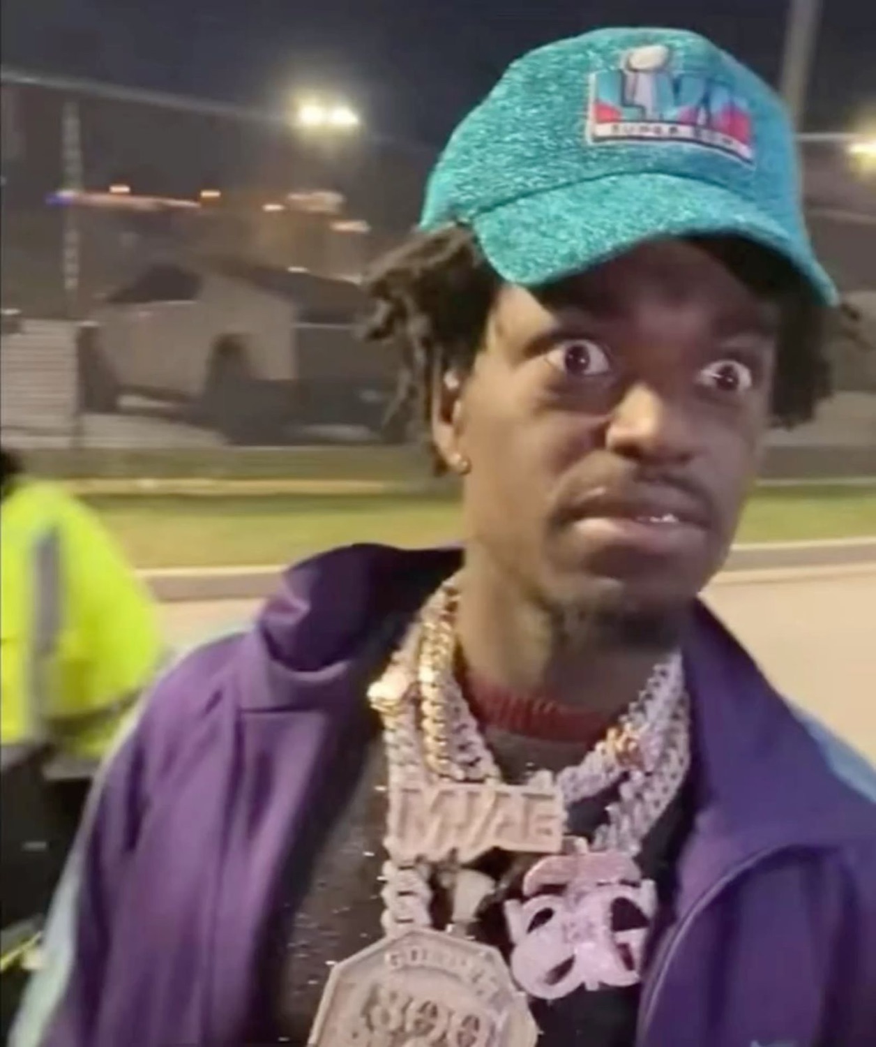 Guy in a Super Bowl cap and iced-out chains looking absolutely shook